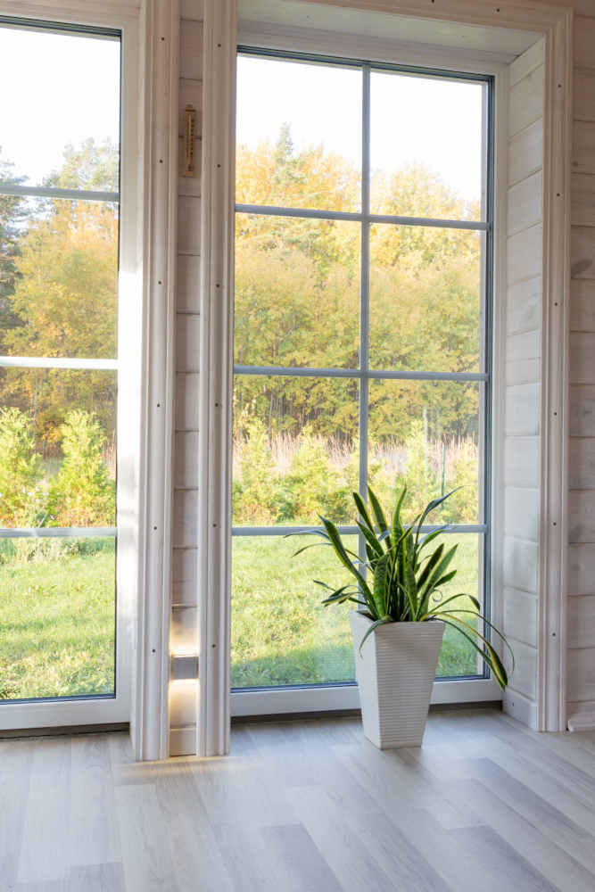 Bright photo studio interior with big window, high ceiling, white wooden floor